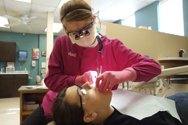 Student performs oral cleaning